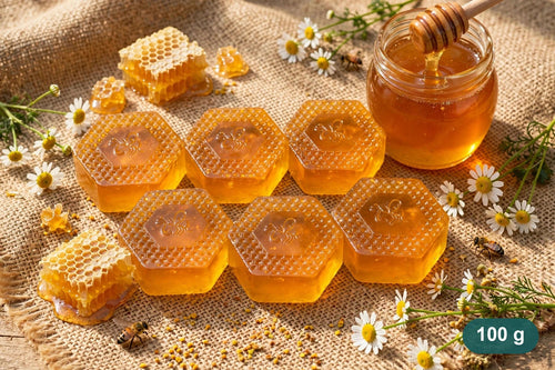 Klyvaa Bath honey soaps, 100 g each, arranged with honeycomb and a honey jar